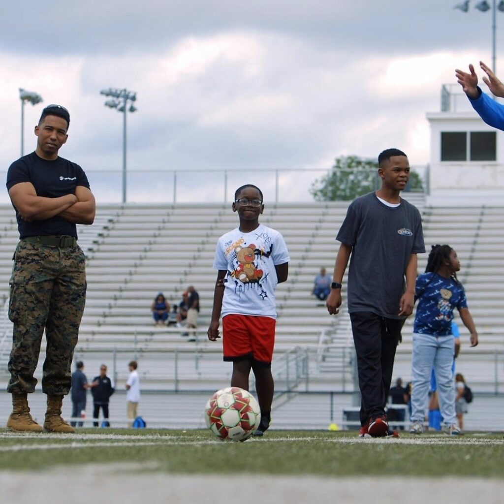 Children, Marines And FC Birmingham Players Enjoying Soccer Drills At The BCS Let's Move Community Huddle.